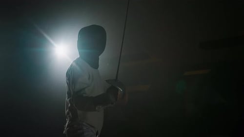 Male Foil Fencer Putting on Epee Mask and Starting Fight with Partner