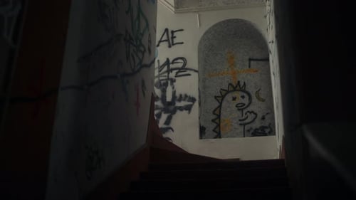 Old abandoned stairway with graffiti on building walls, dolly view up stairs, POV