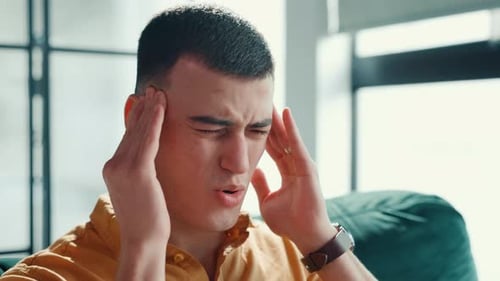 Young Adult Massaging Temples in Pain