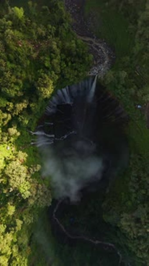 Zumbido vertical desde arriba hacia abajo descendiendo sobre la cascada de Tumpak Sewu, Java Oriental
