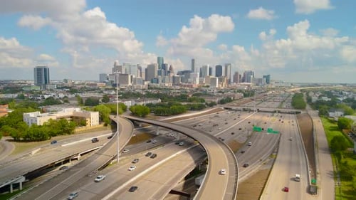 Busy Multi Level Highway Interchange Leading Towards A Modern City Skyline