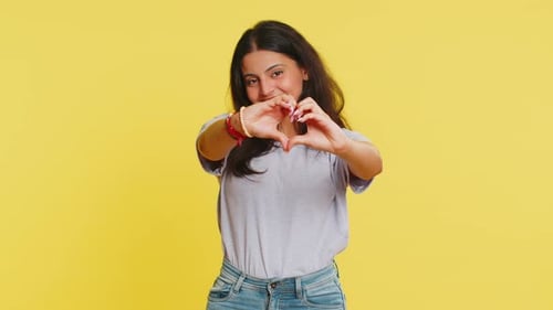 Smiling Woman Makes Heart Shape with Hands