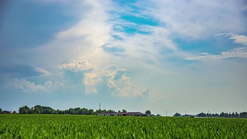 Stormy cloudscape flows over countryside landscape, time lapse