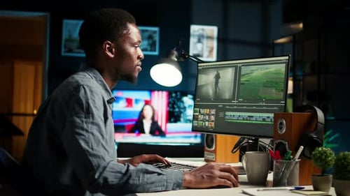African American Videographer Works on Editing Film Footage at Home
