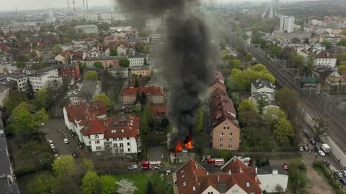 Scène d'incendie de maison intense avec des pompiers luttant contre la fumée des flammes depuis le toit