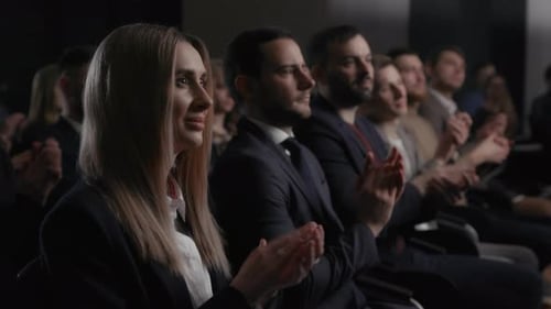 Audience Applauds Speakers in Conference Room Meeting
