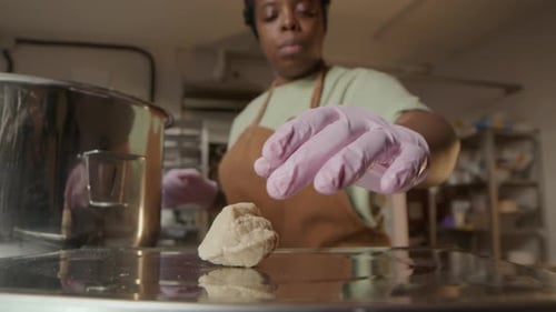 Baker Weighing Dough on Scales and Making Balls with Gloved Hands