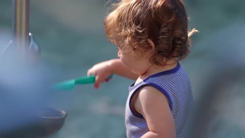 Toddler Plays with Water Feature in the Sunshine