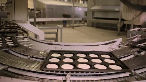 Time-lapse of trays of dough transferred automatically inside bread factory