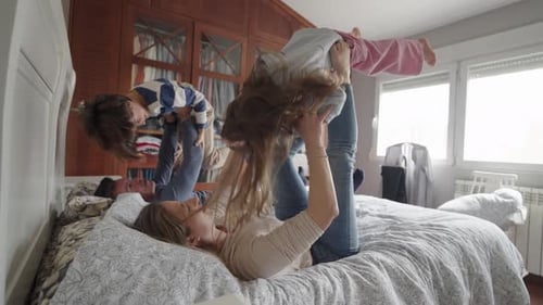 Family Playing Together on Bed Indoors
