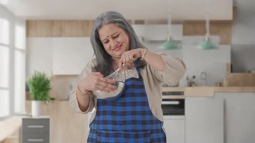 Woman Mixing Ingredients in Kitchen with Whisk