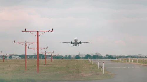 Unrecognizable Plane Takes Off From Airport Runway and Flies Overhead Front View Passenger Airplane