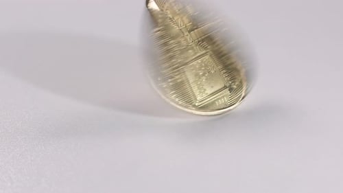 Bitcoin spinning on a white table.