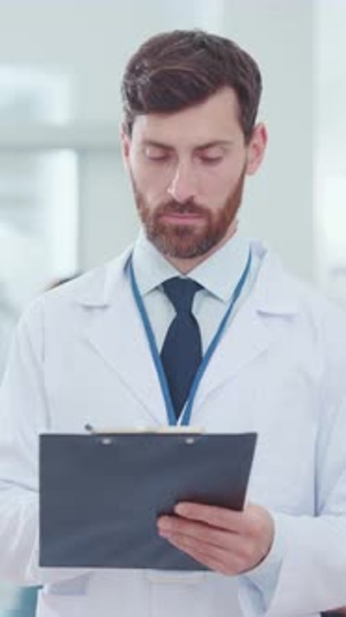 Smiling Male Doctor with Clipboard in Hospital Setting