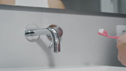 Brushing Teeth Bathroom Extrusion of Multicolored Striped Toothpaste on Brush in Bathroom on the