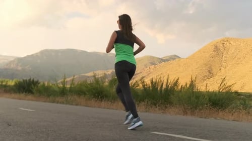 Athlete Runs a Mountain Road at Sunset Inspired for Professional Sports