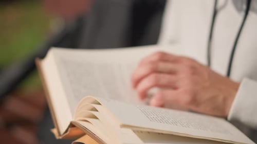 Close-Up of Hands Turning Pages in an Old Book