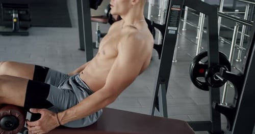 Young sporty man has workout at gym and doing crunch exercise for perfect abs