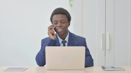 Professional Young Adult Talking on Cell Phone in Office