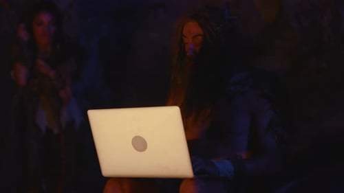 A Caveman Embracing and Utilizing Modern Technology in a Primitive and Ancient Setting