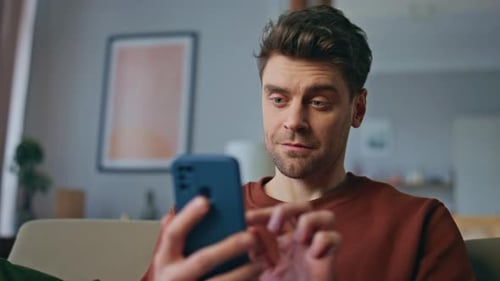 Man Using Smartphone in Living Room Smiling