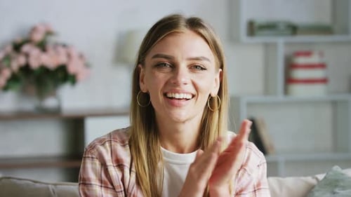 Smiling Woman Clapping at Home on Couch
