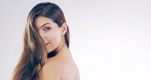 4k video footage of a beautiful young woman flicking her hair in the studio