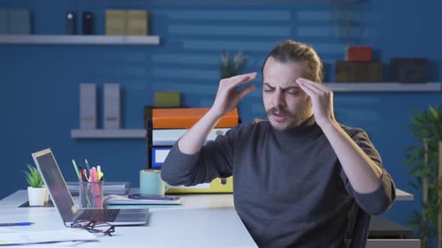 Young man with headache suffering from aches and pains.