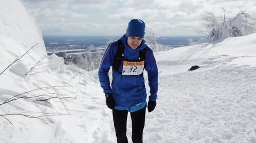 Winter sports. Clip. Men in sports uniforms with numbers who run through the snow at competitions.
