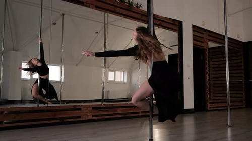 Woman Performs Pole Dance in Studio with Mirrors