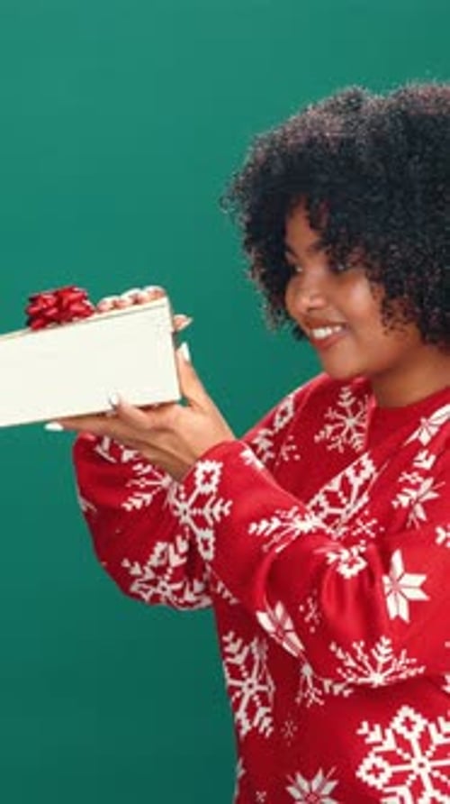 Christmas, open gift and face of woman in studio for holiday, surprise and festive season sale