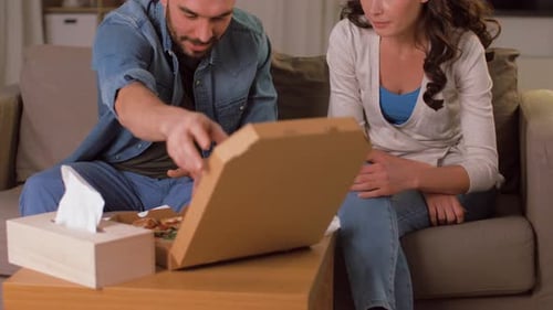 Couple Sharing Pizza on Couch at Home