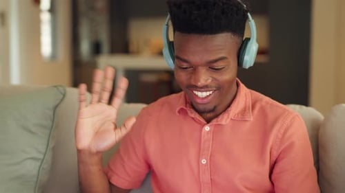 Young Man Chatting Online with Headphones at Home