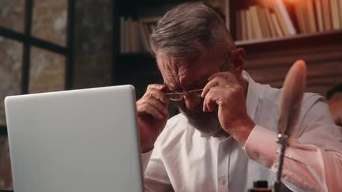 Senior Man Typing on Laptop in Stately Home Office