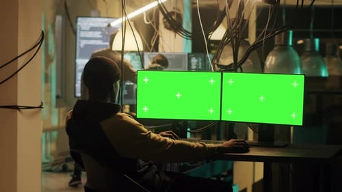 Hacker überprüft Computerbildschirm mit Greenscreen