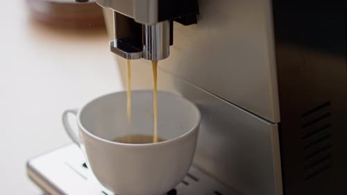 Espresso coffee machine filling cup with coffee beverage