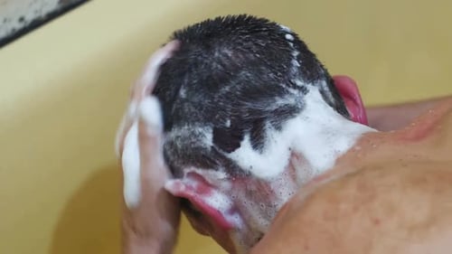 Man Washing Hair with Shampoo in Shower