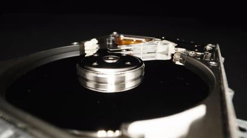 Disque dur d'ordinateur démonté, sur fond noir. Réparer. Dolly Slider en très gros plan.