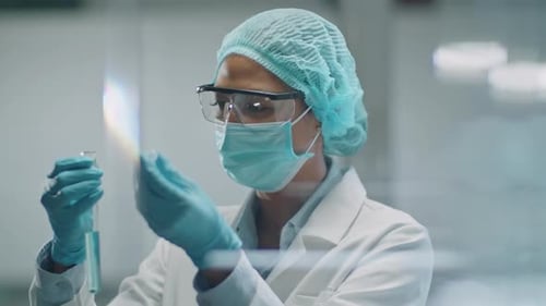 Woman Scientist Examines Liquid in Test Tube
