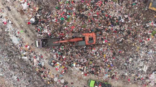 Aerial view of garbage landfill with excavator working