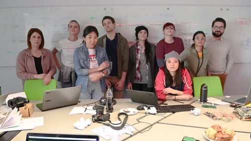 Diverse team posing by a whiteboard in office