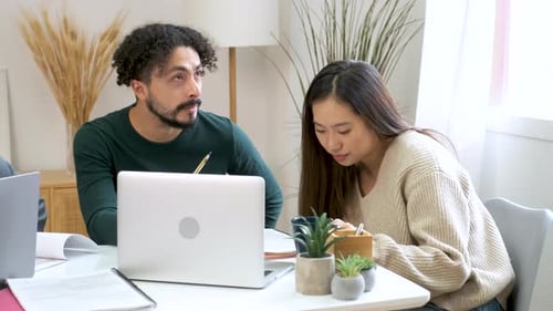 Colleagues Collaborating on Laptop Indoors