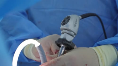 Surgeon Performing Operation with Surgical Equipment