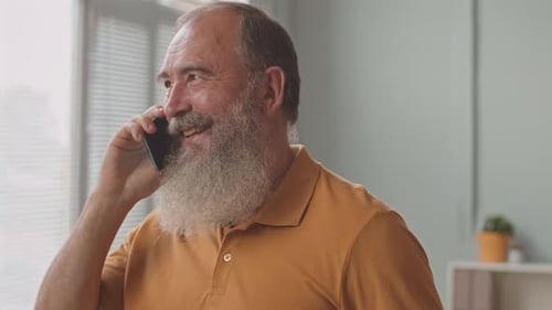 Senior Man Talking on Smartphone Indoors