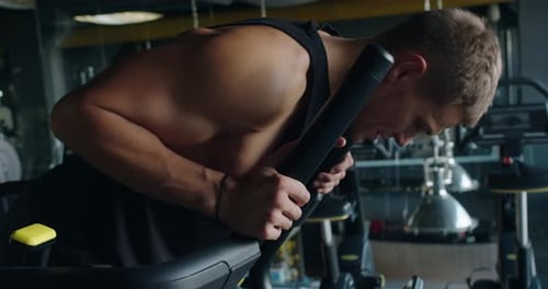 Determined Young Man Exercising With Focus in a Modern Gym