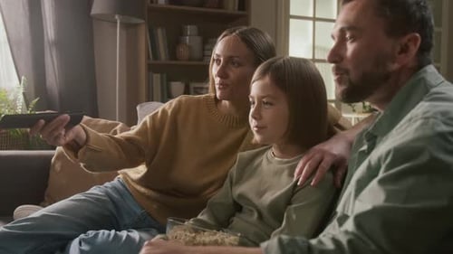 Happy Family Relaxing and Watching TV at Home