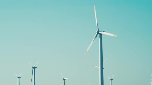 Alternative Energiequellen. Große rotierende Windturbinenblätter vor blauem Himmel
