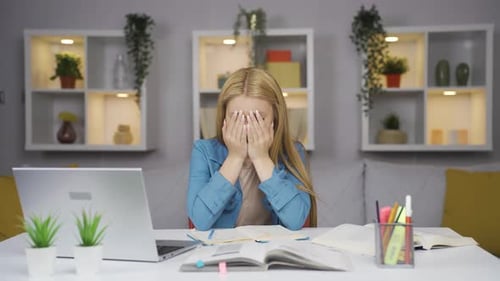 Woman Frustrated Studying at Desk with Laptop