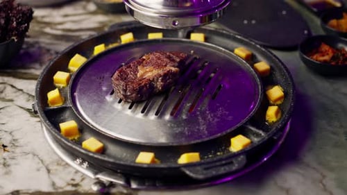 close up of delicious appetizing juicy piece of grilled meat with cheese being fried in restaurant