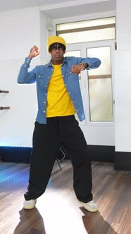 Young man in blue jacket dancing indoors